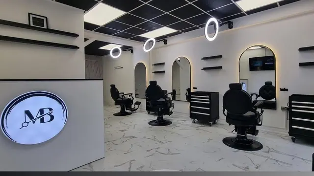 The shop: barber chairs under ring lights, arched mirrors on the wall